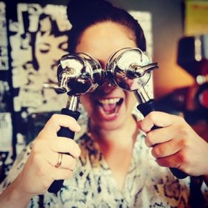 Happy Coffee Circus Community member at Piano Vilnius cafÃ© holding espresso portafilter in playful moment, capturing the interactive specialty coffee culture and community spirit