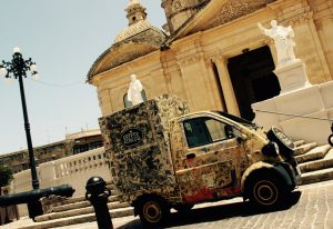 Coffee Circus Baby mobile coffee cart parked in front of historic church in Malta
